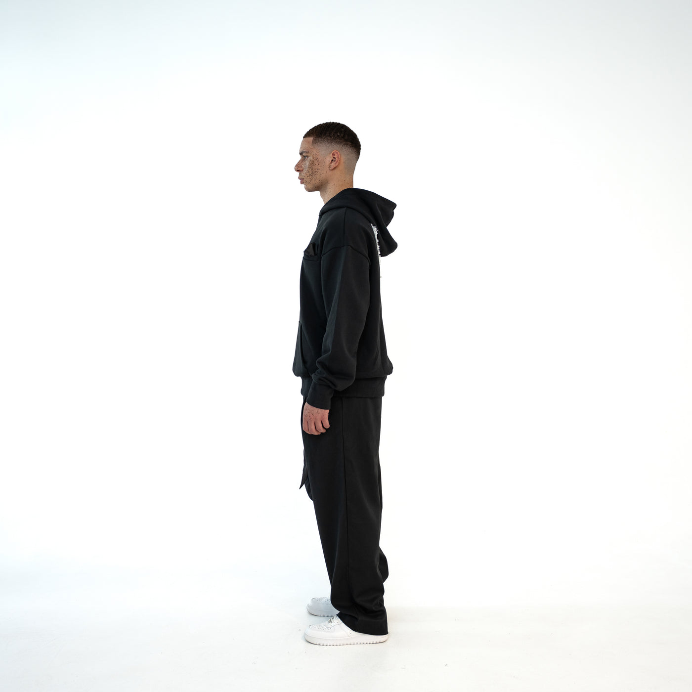 TenProcentr BASTILLE Heavyweight Hoodie 500 GSM in Schwarz, Seitenansicht am Model zeigt Kapuze und oversized Passform