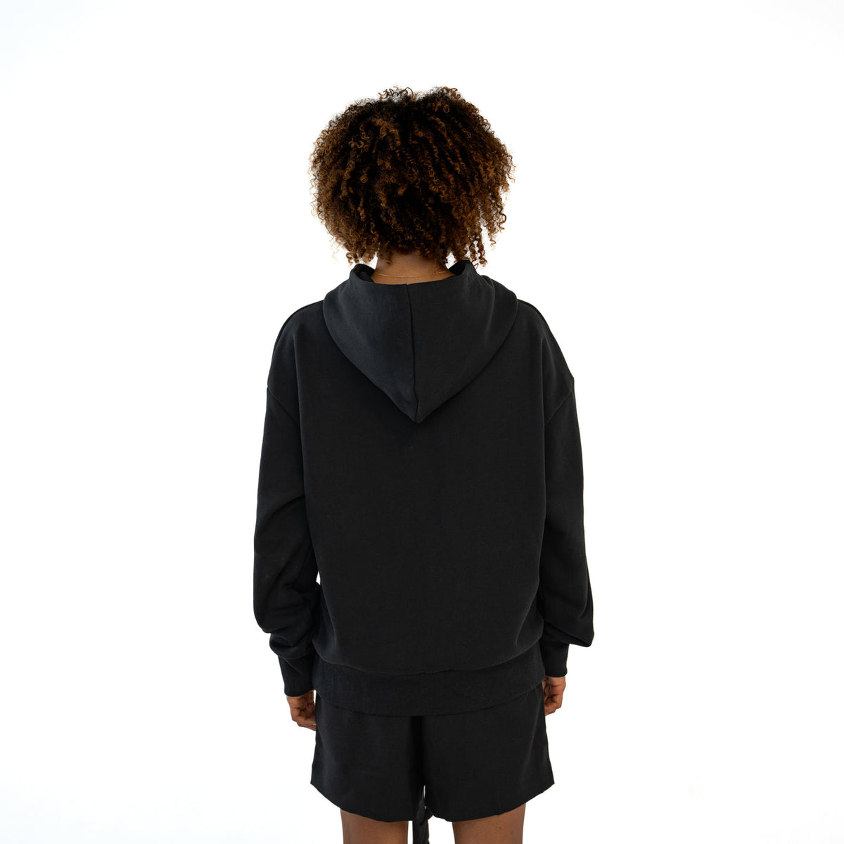 TenProcentr CHIFFON Heavyweight Hoodie in Schwarz, Rückansicht am Model mit Kapuzen-Detail und Rippbund