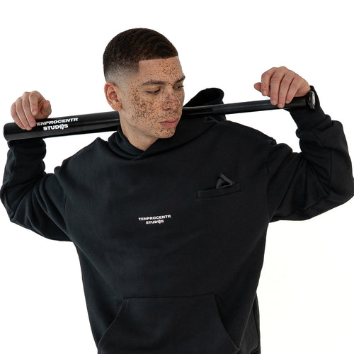 TenProcentr CHIFFON Heavyweight Hoodie in Schwarz an Model, Vorderansicht mit Logo-Print und Kängurutasche