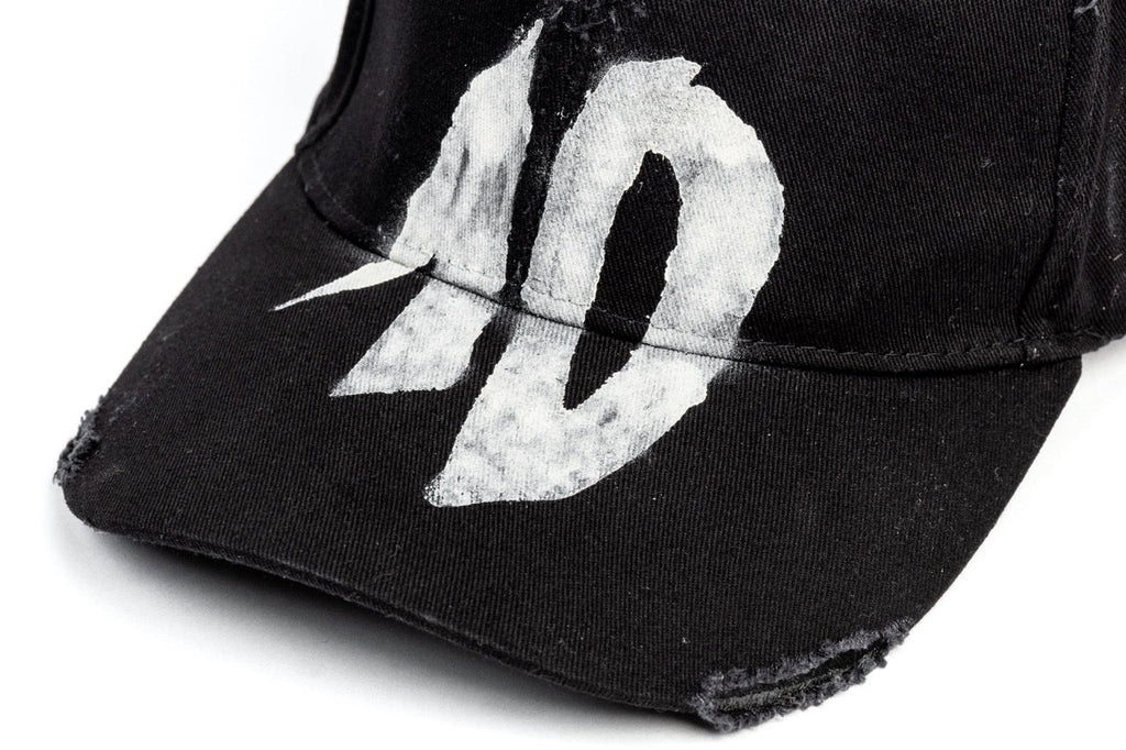 TenProcentr DIX Baseball Cap Detailaufnahme der weißen 10-Stickerei im Vintage-Stil auf schwarzem Stoff