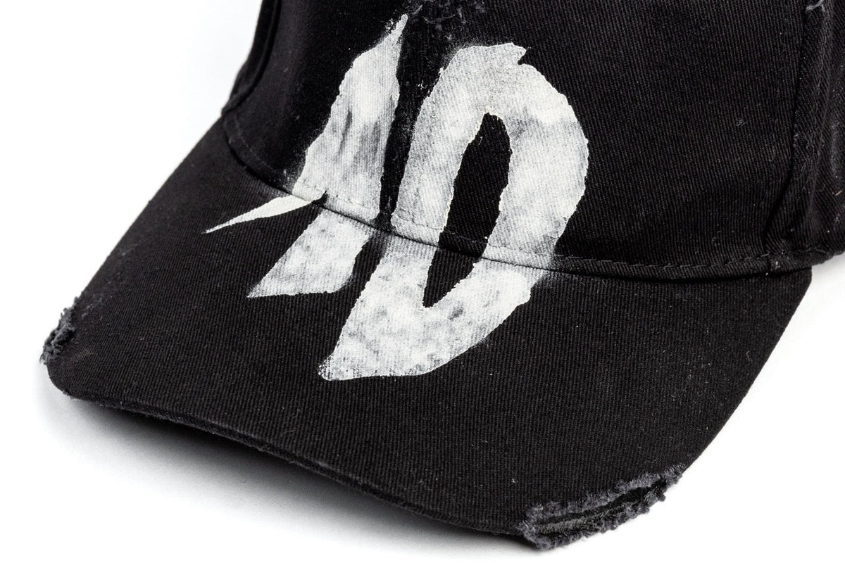 TenProcentr DIX Baseball Cap Detailaufnahme der weißen 10-Stickerei im Vintage-Stil auf schwarzem Stoff