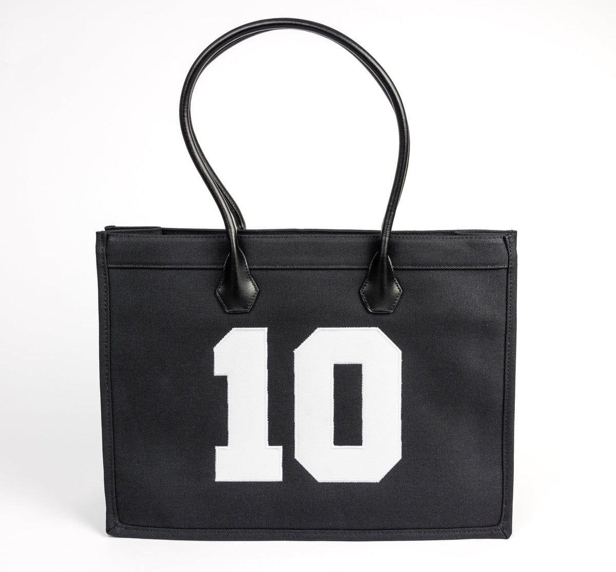 TenProcentr DIX Canvas Tote Bag in Schwarz, Frontansicht mit weisser 10-Applikation und schwarzen Lederhenkeln