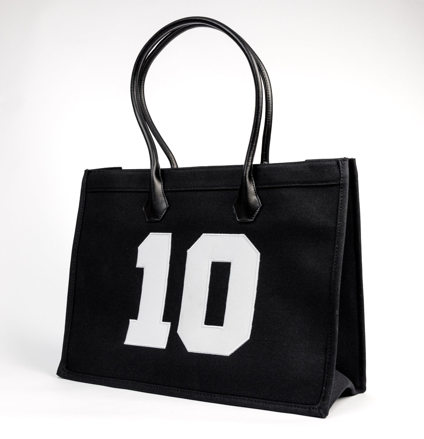 TenProcentr DIX Canvas Tote Bag in Schwarz, Seitenansicht mit grosser weisser 10-Applikation und Lederhenkeln