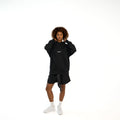 TenProcentr EN MARGE Heavyweight Hoodie in Schwarz, Vorderansicht am Model mit Brust-Logo und Kapuze