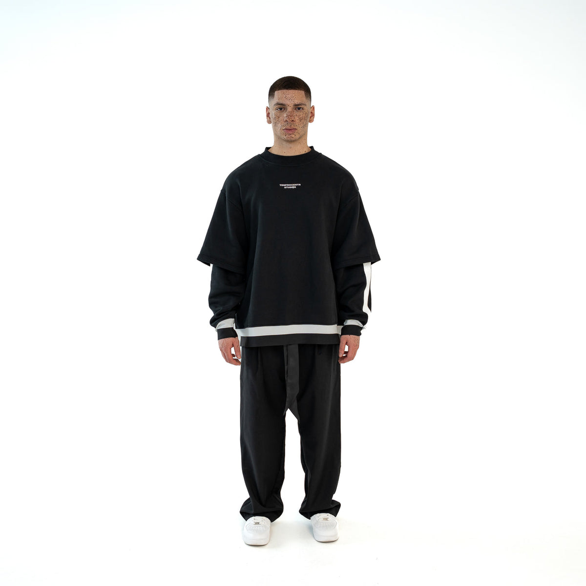 TenProcentr MUR Double-Layer Sweater in Schwarz, Frontansicht am Model mit weiss abgesetzter Doppellagen-Optik