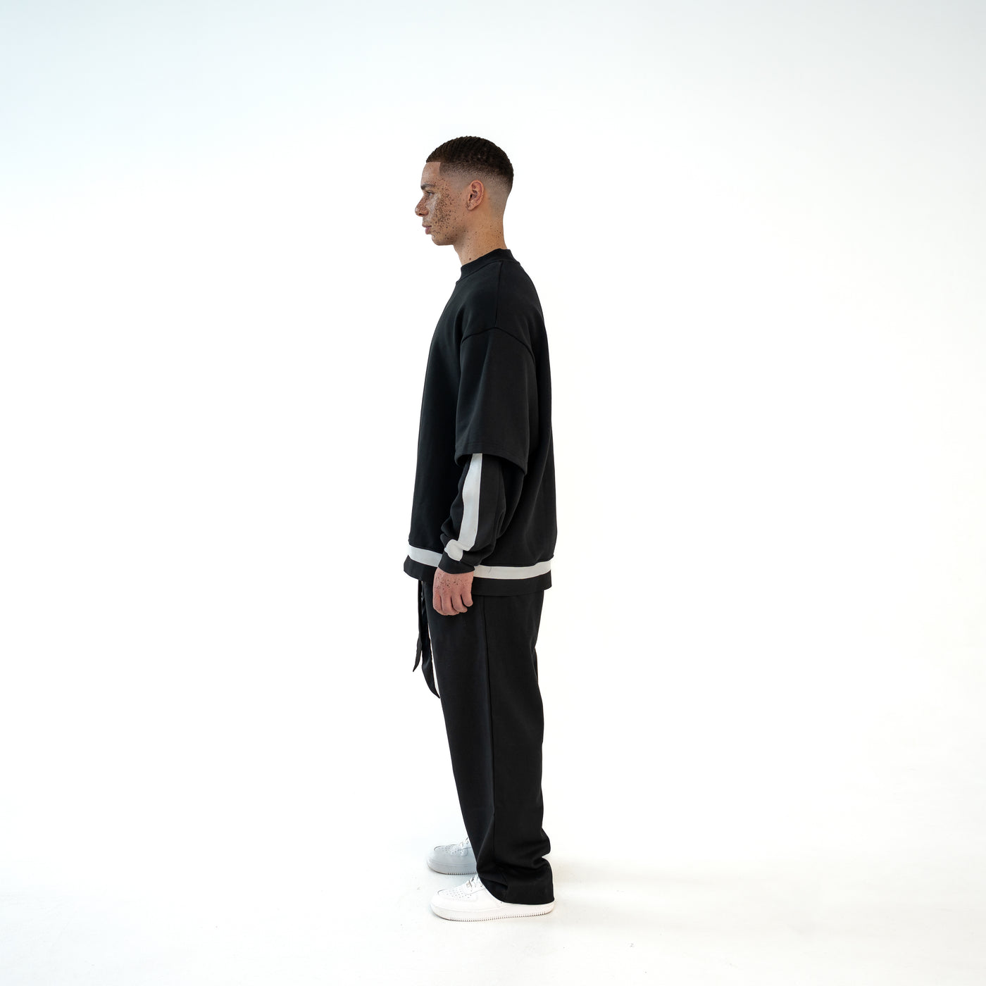 TenProcentr MUR Double-Layer Sweater in Schwarz, Seitenansicht am Model zeigt oversized Schnitt und Layer-Aermel