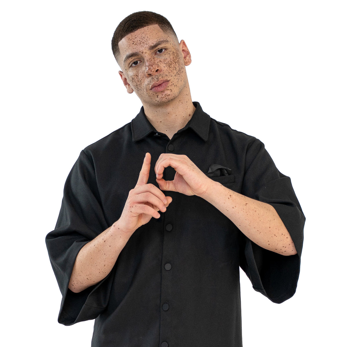 Detailaufnahme des schwarzen TenProcentr OUTFIELD Oversized Shirts am Model, zeigt Kragen, Druckknöpfe und Brusttasche