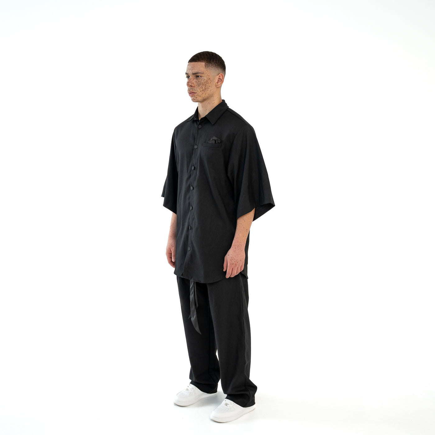 TenProcentr OUTFIELD Oversized Shirt in Schwarz, am Model schräg von vorne, zeigt lockeren Schnitt und weite Ärmel