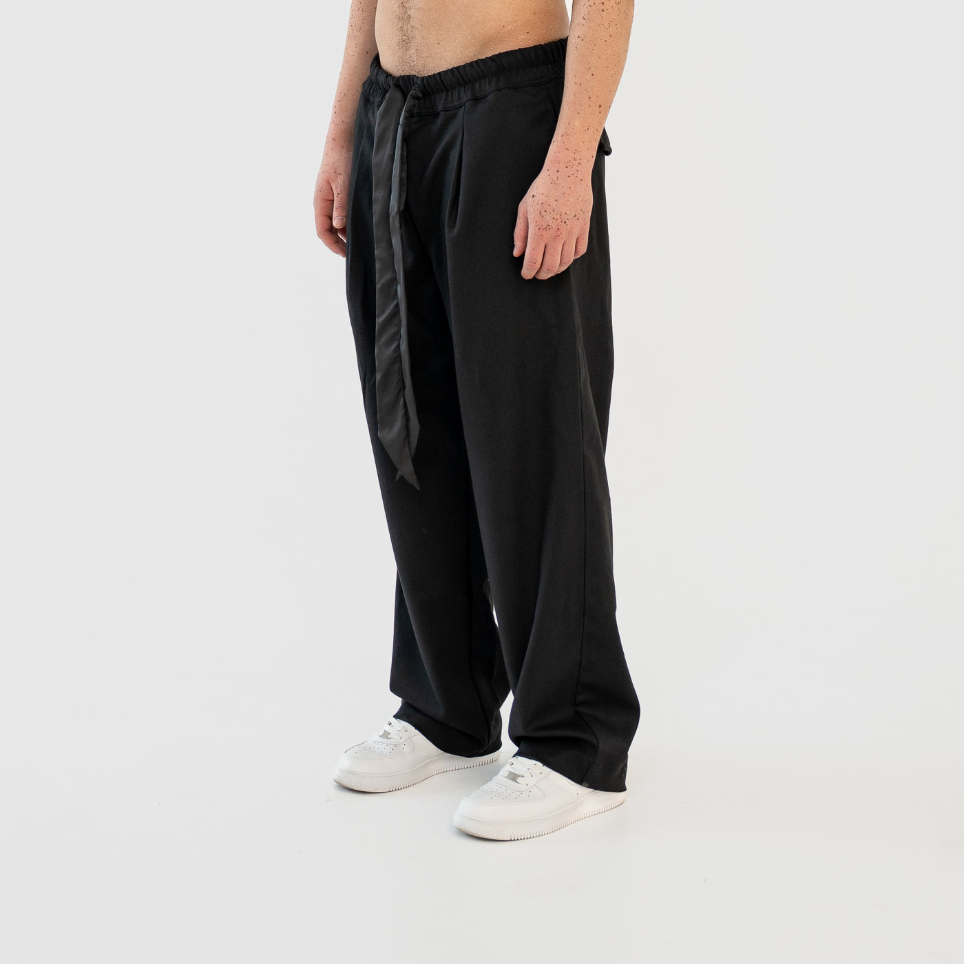 TenProcentr VALLET Tailored Pants am Model in der Dreiviertel-Ansicht, weiter Schnitt mit Satin-Kordel