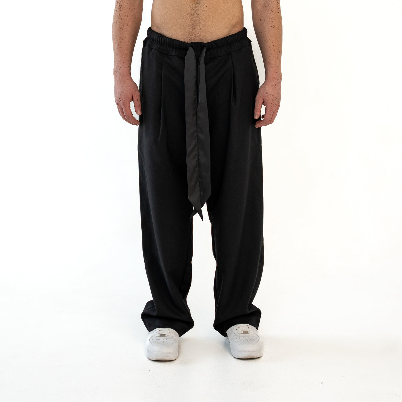TenProcentr VALLET Tailored Pants in Schwarz, Vorderansicht am Model mit hängendem Satin-Kordelzug