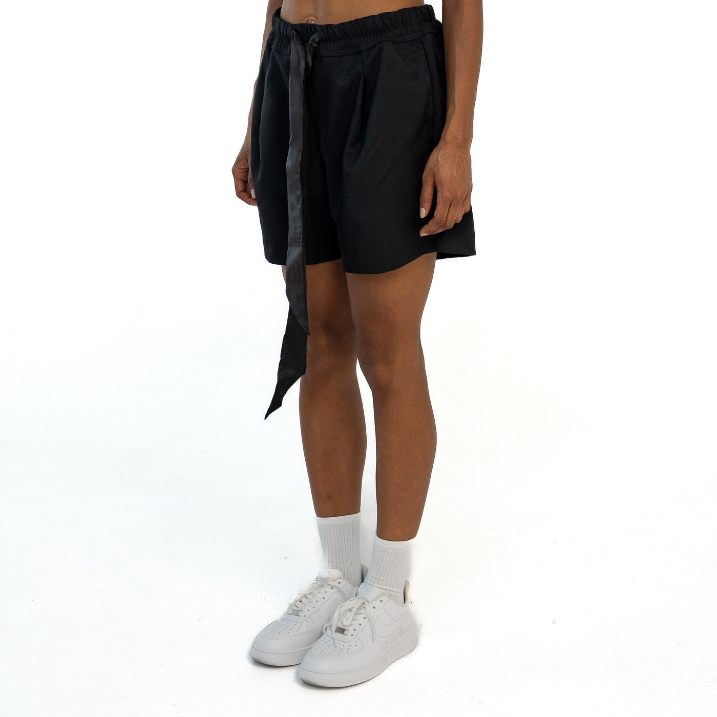 TenProcentr VALLET Tailored Shorts en noir, vue de côté en trois quarts sur mannequin avec ruban en satin retombant