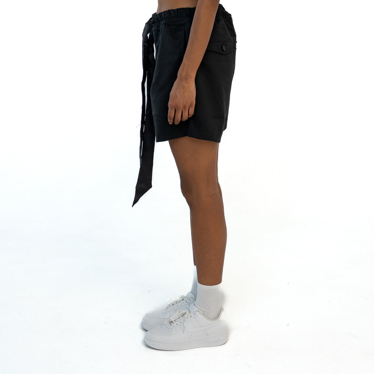 TenProcentr VALLET Tailored Shorts en noir, vue de profil sur mannequin avec poche à rabat et long cordon en satin