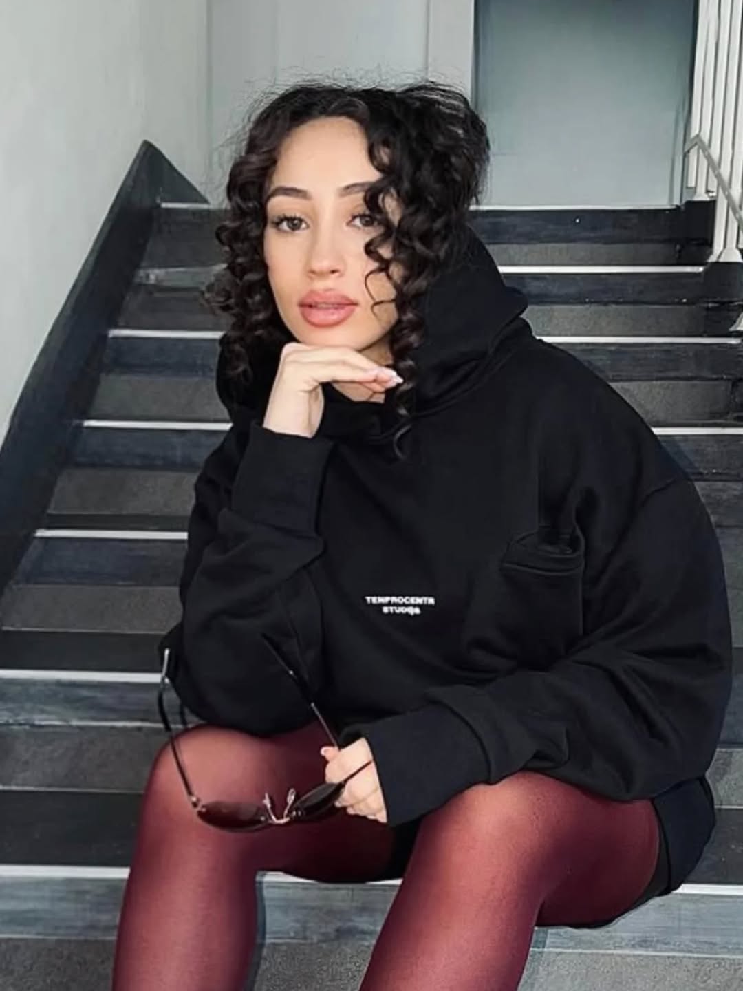 TenProcentr Oversized Hoodie an Model auf dunkler Treppe, editorial